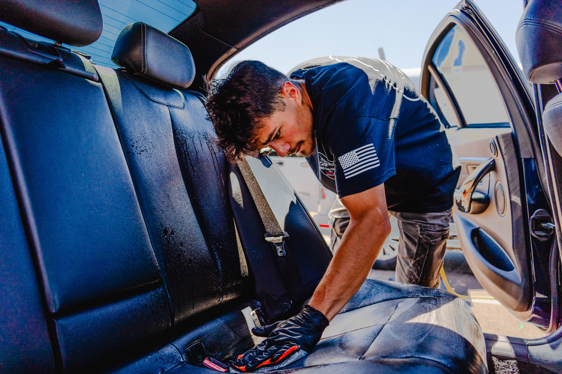 A&B Auto Shine detailer scrubbing a leather rear seat